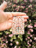 Beaded earrings in a floral abstract pattern in a rose garden