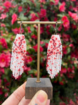 Handmade beaded cherry blossom earrings in a rose garden